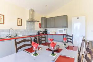 a kitchen with a table with red flowers on it at Amber Cabin in Ashover