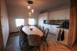 a kitchen with a dining room table and chairs at Luxe buitenhuis 10 pers met jacuzzi en vrij uitzicht in Rheeze
