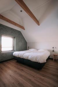 a bedroom with a large bed in a attic at Luxe buitenhuis 10 pers met jacuzzi en vrij uitzicht in Rheeze