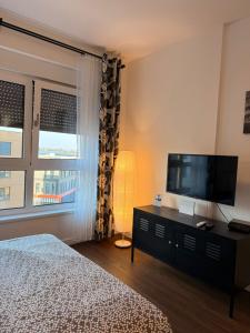 a bedroom with a bed and a flat screen tv at Fantasia apartmani - Tesla palace in Kragujevac