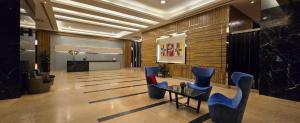 eine Lobby mit blauen Stühlen und einem Tisch in einem Gebäude in der Unterkunft The Elements @ Ampang in Kuala Lumpur