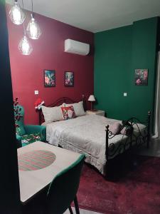una camera da letto con pareti verdi e rosse e un letto di La Familia a Veria