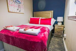 a bedroom with a large bed with red pillows at Mayfield House in Dalkeith