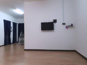 a room with a white wall and a flat screen tv at Marang Private Pool Homestay - 3-Bedroom - Family & Group Stay in Marang