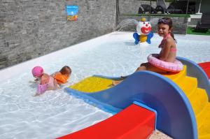 two children playing in an indoor swimming pool at Camping L'Oustalet in Châtel