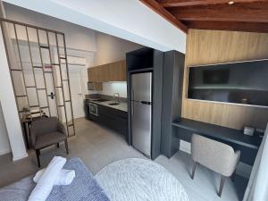 a small kitchen with a bed and a refrigerator at Estúdios Completos no Centro de Floripa - CMA in Florianópolis
