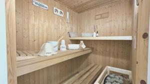a sauna with wooden walls and shelves in a room at Strandhaus Rügen 243 in Baabe