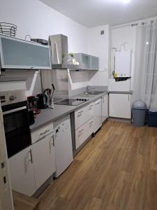 a kitchen with white appliances and a wooden floor at Grand appart 2 chambres - max 6 pers in Vrigne-aux-Bois