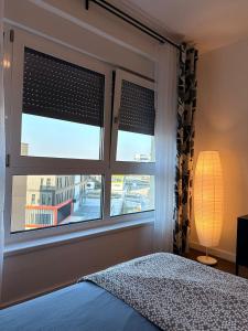 a bedroom with a window with a bed and a lamp at Fantasia apartmani - Tesla palace in Kragujevac +10 photos