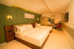 een slaapkamer met twee bedden en een groene muur bij Hotel Harriet in Rāmeswaram +58 foto's