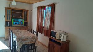 a kitchen with a table and a tv on a counter at Cabaña Juana Vg in Villa Giardino +13 photos