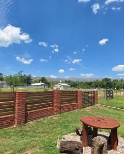 a wooden table in front of a fence at Cabaña Juana Vg in Villa Giardino