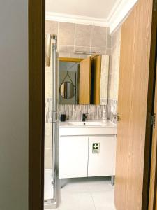 a bathroom with a white sink and a mirror at Cantinho de Belmonte in Belmonte +15 photos