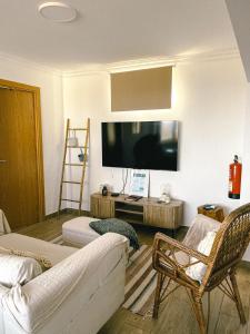 a living room with a couch and a flat screen tv at Cantinho de Belmonte in Belmonte