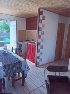 a room with a table and a kitchen with a counter at Cabaña Juana Vg in Villa Giardino