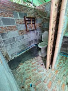 a bathroom with a toilet in a brick wall at Faiza Farm home in Ban Nong Phai