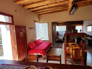 een woonkamer met een rode bank en een tafel bij Cabañas Mallma in Tilcara +17 foto's