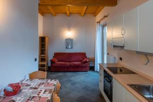 a kitchen with a red couch in a room at Camping Dolomiti in Dimaro