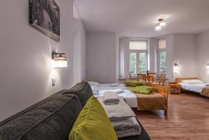 ein Wohnzimmer mit zwei Betten und einer Couch in der Unterkunft HUZAR in Krynica-Zdrój