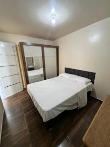 En eller flere senge i et værelse på Quarto casal Com mais 1 cama solteiro 2 andar FT