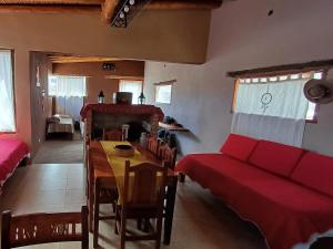 een woonkamer met een rode bank en een tafel bij Cabañas Mallma in Tilcara