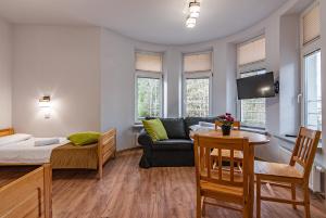 ein Zimmer mit einem Bett, einer Couch und einem Tisch in der Unterkunft HUZAR in Krynica-Zdrój