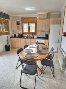 een keuken met een tafel met stoelen en een koelkast bij Amarella Costa Dorada in Les tres Cales