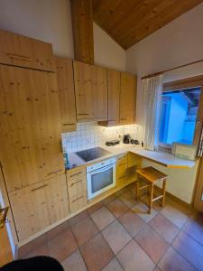 a kitchen with wooden cabinets and a table in it at Glory Igls Lodge in Innsbruck