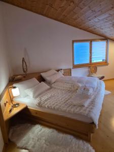 a large bed in a bedroom with a window at Glory Igls Lodge in Innsbruck