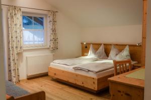 a bedroom with a wooden bed and a window at Bauernhof Krahlehenhof in Filzmoos