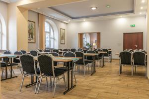ein Konferenzraum mit Tischen und Stühlen in der Unterkunft HUZAR in Krynica-Zdrój