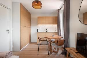 een kleine keuken en eetkamer met een tafel en stoelen bij Marrakech - Gare - CEA - STMicro in Fontaine +7 foto's