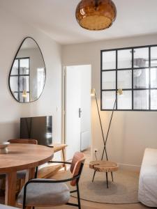 een woonkamer met een tafel en een spiegel bij Marrakech - Gare - CEA - STMicro in Fontaine