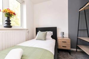 a bedroom with a bed and a vase of flowers on a window at DiscountsContractorsWIFIFree ParkingSmart TV in Durham