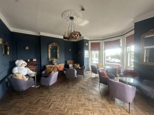 een wachtkamer met blauwe muren en stoelen en een teddybeer bij West Rocks Townhouse in Eastbourne