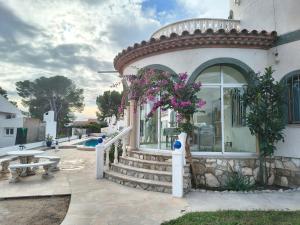 een gebouw met een trap en een raam met paarse bloemen bij Amarella Costa Dorada in Les tres Cales