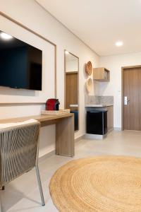 a living room with a flat screen tv and a kitchen at Wyndham Natal Pitangui Praia in Extremóz