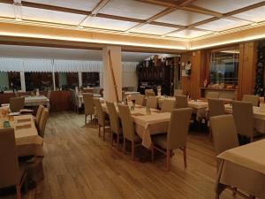 a restaurant with tables and chairs in a room at Albergo Ristorante Cacciatori in Auronzo di Cadore