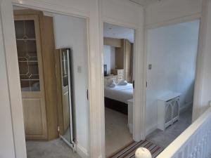 een kamer met een slaapkamer met een bed en een spiegel bij Comfy Home- Coley Park in Reading