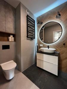 ein Badezimmer mit Toilette, Waschbecken und Spiegel in der Unterkunft Wroclove Apartments in Breslau + 59 Fotos