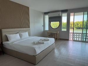 - une chambre avec un grand lit, une table et des fenêtres dans l'établissement Madee House - มาดีเฮ้าส์, 