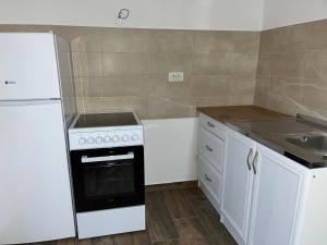 a white kitchen with a stove and a sink at Mimura 3 in Belgrade