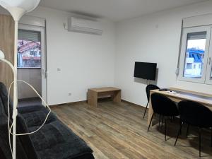 a living room with a couch and a desk and a tv at Mimura 3 in Belgrade