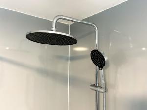 een douche met een douchekop in een badkamer bij Scamnel in Norton Bridge