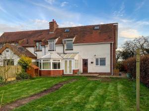 een groot wit huis met een grasveld bij Scamnel in Norton Bridge