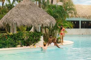 Un grupo de personas en la piscina de un resort. en Zel Punta Cana - All Suites, en Punta Cana