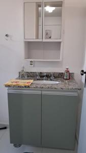 een aanrecht met een wastafel en witte kasten bij Smart Flat Apartamento A 64 in Mogi das Cruzes