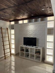 een woonkamer met een televisie en een bakstenen muur bij Saidia luxury in Saidia 