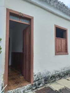 eine offene Tür eines weißen Gebäudes mit einem Fenster in der Unterkunft Casa no Centro da cidade! in Goiás