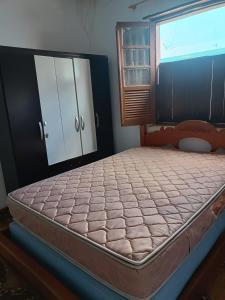 ein großes Bett in einem Schlafzimmer mit Fenster in der Unterkunft Casa no Centro da cidade! in Goiás